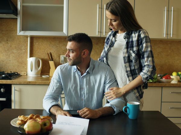 A couple going through paperwork at their kitchen table