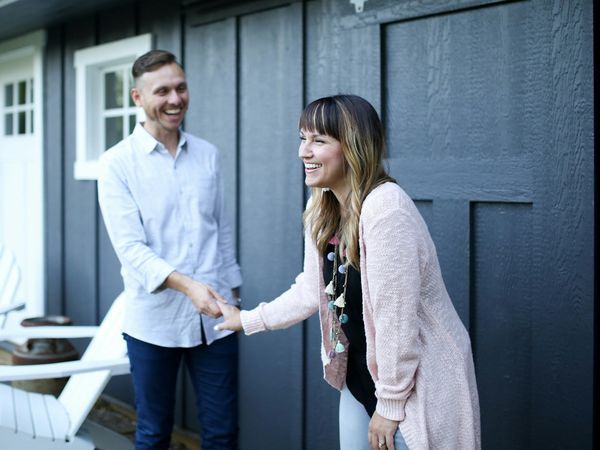 An agent greeting a homeowner at the front door