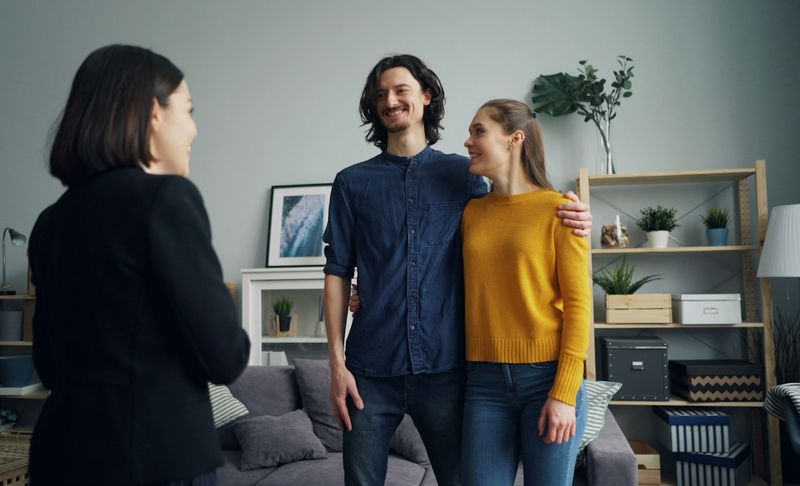 A local agent talking with a couple in their living room