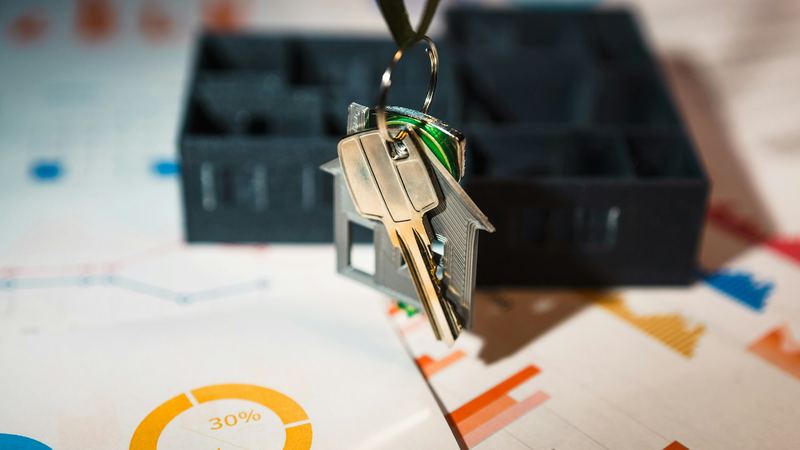 House keys and model houses on printed property papers