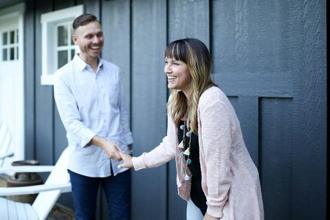 An agent greeting a homeowner at the front door